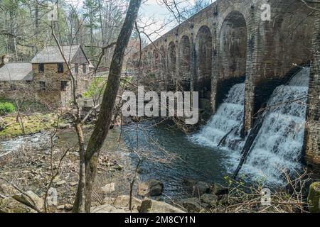 De l'autre côté du pont en pierre avec l'eau qui coule vers le bas, c'est un barrage avec le moulin Lodge dans le fond à la montagne Cumberland Banque D'Images