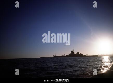 Le cuirassé USS WISCONSIN (BB-64) est silhoueté contre le ciel de la fin de l'après-midi comme il se trouve à l'ancre près des États-Unis Station navale, Baie de Guantanamo, Cuba. Pays: Mer des Caraïbes Banque D'Images