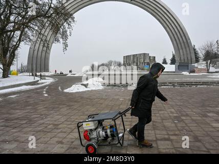 Kiev, Ukraine. 13th janvier 2023. Un homme tire un générateur à côté de l'Arc de liberté à Kiev, dans le cadre de l'invasion russe de l'Ukraine. Après de graves dommages au réseau électrique dans de nombreuses villes d'Ukraine à la suite d'attaques massives de roquettes et de drones kamikaze russes, la compagnie nationale d'électricité Ukrenergo a introduit l'urgence et des coupures d'électricité planifiées. La Russie a envahi l'Ukraine le 24 février 2022, déclenchant la plus grande attaque militaire en Europe depuis la Seconde Guerre mondiale (Credit image: © Sergei Chuzavkov/SOPA Images via ZUMA Press Wire) USAGE ÉDITORIAL SEULEMENT! Non destiné À un usage commercial ! Banque D'Images
