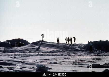 Le personnel naval travaille près d'un hélicoptère UH-1N Iroquois. Ils appuient des opérations sous la glace arctique par les sous-marins à propulsion nucléaire USS GURNARD (SSN 662) et USS SEAHORSE (SSN 669). Base: Camp de glace Aplis pays: Océan Arctique Banque D'Images