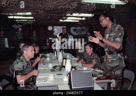 LE GÉN Colin Powell, à gauche, président des chefs d'ÉTAT-MAJOR interarmées, est assis pour prendre un café avec LE MGÉN Fred A. Gorden, commandant général, 25th, Division d'infanterie (légère), et d'autres officiers lors d'une visite du Centre d'instruction d'infanterie légère de la division. Base : casernes Schofield, Kaneohe Bay État : Hawaï (HI) pays : États-Unis d'Amérique (USA) Banque D'Images