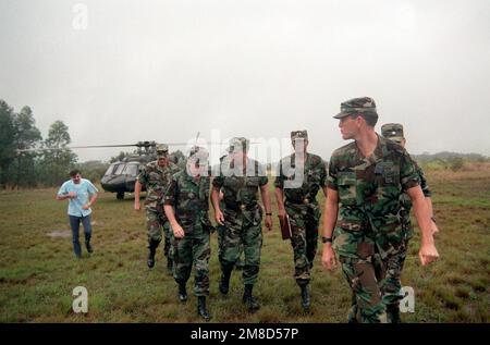 LE GÉNÉRAL Colin Powell, au centre, président des chefs d'ÉTAT-MAJOR interarmées, s'entretient avec un officier après avoir débarqué d'un hélicoptère UH-60A Black Hawk pour rendre visite aux troupes sur le terrain. LE MGÉN Fred A. Gorden, commandant général, 25th, Division d'infanterie (légère), marche sur la gauche de Powell. Base : casernes Schofield, Kaneohe Bay État : Hawaï (HI) pays : États-Unis d'Amérique (USA) Banque D'Images