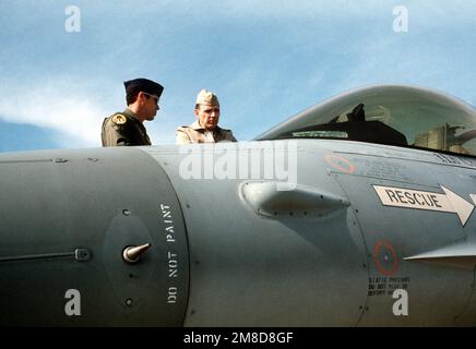 L'amiral Jonathan T. Howe, à droite, commandant en CHEF des Forces alliées en Europe du Sud, s'entretient avec un officier de l'Armée de l'Air américaine lorsqu'il voit un avion Faucon F-16 de combat comme faisant partie d'un étalage statique d'avions de l'OTAN. L'exposition est organisée en conjonction avec l'exercice Dragon HAMMER '90 de la région du Sud de l'OTAN. Sujet opération/série: DRAGON HAMMER '90 pays: Italie (ITA) Banque D'Images