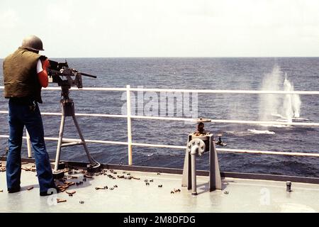 Un membre de l'équipage à bord du navire de commandement amphibie USS BLUE RIDGE (LCC-19) tire une mitrailleuse de calibre M-2 .50 pendant les qualifications à armes légères. La BLUE RIDGE fait partie des États-Unis Des navires de la Marine ont été déployés dans la région à l'appui de l'opération Desert Shield. Sujet opération/série: BOUCLIER DU DÉSERT pays: Inconnu Banque D'Images