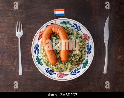 Une assiette avec un repas traditionnel hollandais « Stamppot Boerenkool met Mest » composé de pommes de terre écrasées avec du chou vert, de saucisses fumées et de sauce Banque D'Images