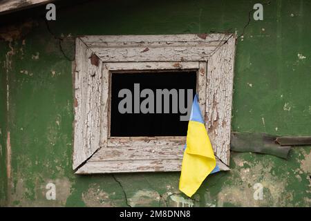 Le drapeau de l'Ukraine est accroché à la fenêtre d'un immeuble d'habitation détruit, de la guerre et des bombardements de bâtiments d'habitation russes en Ukraine Banque D'Images