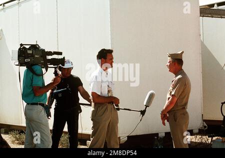 Une équipe de la SCS a interviewé un membre du Service de radiodiffusion de la Marine à l'installation du système de radio et de télévision des Forces armées pendant l'opération Desert Shield. Objet opération/série : BOUCLIER DU DÉSERT base : Dhahran pays : Arabie saoudite (SAU) Banque D'Images