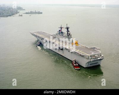 Les membres de l'équipage s'en prennent aux rails tandis que les remorqueurs du port mangent le navire d'assaut amphibie USS WASP (LHD 1) dans le port. Base: Naval Air Station, Norfolk État: Virginie (va) pays: Etats-Unis d'Amérique (USA) Banque D'Images