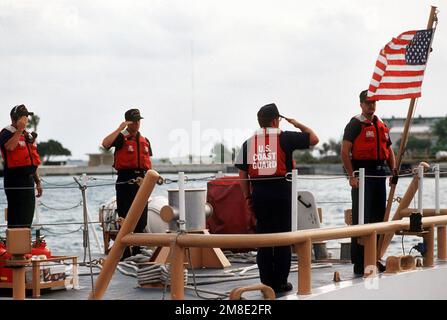 Les membres de équipage à bord du grand patrouilleur de la Garde côtière USCGC KISKA (WPB-1336) saluent que les couleurs sont élevées après leur arrivée à l'atoll lors de l'opération Steel Box. Le KISKA est en place pour assurer la sécurité lors de la livraison de munitions chimiques à l'atoll. Objet opération/série: BOÎTE EN ACIER pays: Johnston Atoll Banque D'Images