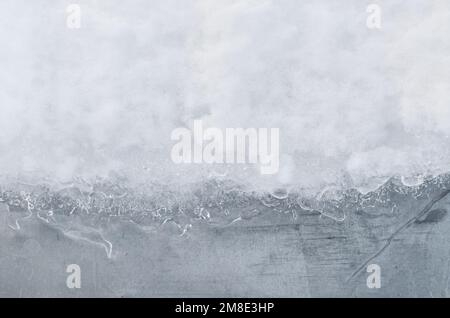 Texture de neige blanche et de glace sur fond de mur gris avec espace de copie. Banque D'Images