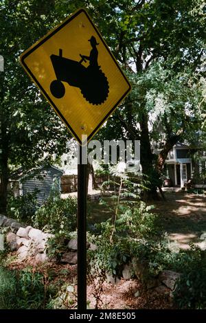 Un panneau jaune Tractor Crossing est suspendu avant l'entrée des fermes communautaires de Codman. Lincoln, Massachusetts. L'image a été capturée sur un film analogique Banque D'Images