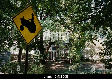 Un panneau jaune Tractor Crossing est suspendu avant l'entrée des fermes communautaires de Codman. Lincoln, Massachusetts. L'image a été capturée sur un film analogique Banque D'Images