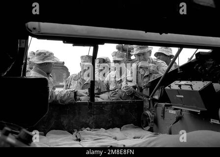 Un membre du 3rd Tank Battalion présente l'intérieur de son véhicule à roues polyvalent de haute mobilité (HMMWV) série M998 à, de gauche à droite, GEN. Alfred M. Gray, commandant du corps des Marines, SGT. MAJ. David W. Sommers, sergent-major du corps des Marines, et LT. GÉN. Walter E. Boomer, commandant général, 1 Marine Expeditionary Force (1 MEF), pendant l'opération Desert Shield. Objet opération/série : BOUCLIER DU DÉSERT pays : Arabie saoudite (SAU) Banque D'Images