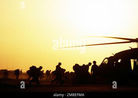 Deux groupes de soldats sont silhouettés contre le ciel lorsqu'ils sont à bord d'hélicoptères UH-60A Black Hawk (Blackhawk) pendant l'opération Desert Shield. Objet opération/série : BOUCLIER DU DÉSERT pays : Arabie saoudite (SAU) Banque D'Images
