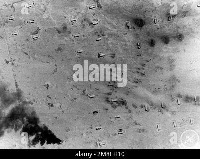 Vue aérienne des bunkers de stockage de missiles iraquiens Scud, dont l'un est encore en feu, à la suite d'une attaque par un avion A-7E Corsair de l'escadron d'attaque 46 (va-46) et de l'escadron d'attaque 72 (va-72) lors de l'opération Desert Storm. La photographie a été prise d'un avion F-14A Tomcat du Fighter Squadron 32 (VF-32) utilisant le système tactique de reconnaissance aérienne (TARPS). Objet opération/série : TEMPÊTE DANS LE DÉSERT pays : Irak (IRQ) Banque D'Images