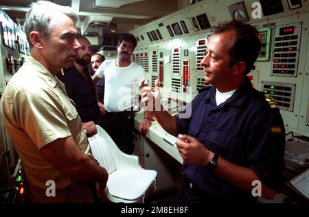 CAPT. Douglas C. Bauer, à gauche, un américain L'historien de la Marine écoute l'officier exécutif de la frégate espagnole Vencedora (F-36) explique les procédures de salle des machines de son navire. Le Vencedora est l'un des navires de la Force d'interdiction maritime (MIF), qui a été formée pendant l'opération Desert Shield pour faire appliquer les sanctions commerciales américaines contre l'Irak. Sujet opération/série: BOUCLIER DU DÉSERT pays: Mer Rouge Banque D'Images