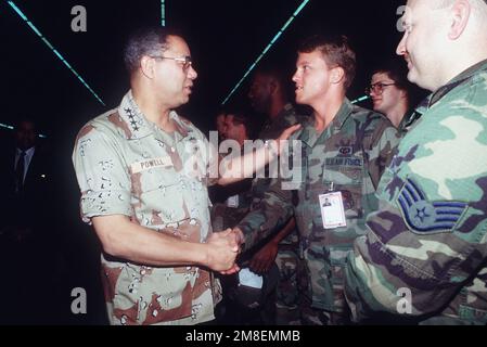 GÉN. Colin Powell, président des chefs d'ÉTAT-MAJOR interarmées, serre la main avec un membre de l'escadre tactique de 37th lorsqu'il visite l'unité pendant l'opération tempête du désert. Objet opération/série : TEMPÊTE DANS LE DÉSERT pays : Arabie saoudite (SAU) Banque D'Images