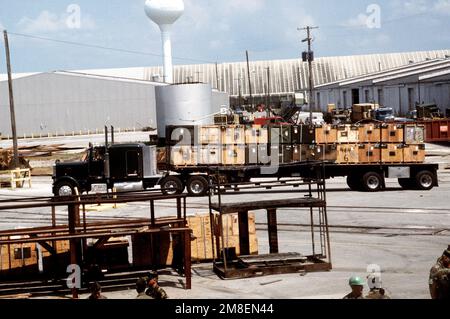 Une remorque de tracteur transportant des caisses de fournitures du corps des Marines se transporte dans une zone de transit. Le matériel sera transporté par navire à destination de l'Arabie saoudite à l'appui de l'opération Desert Shield. Sujet opération/série: DESERT SHIELD base: Morehead City État: Caroline du Nord (NC) pays: États-Unis d'Amérique (USA) Banque D'Images