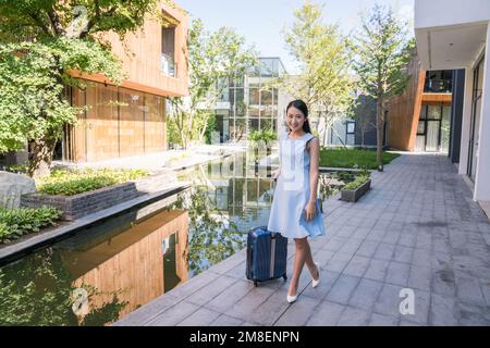 Jeune femme mes bagages utilisent des téléphones cellulaires Banque D'Images