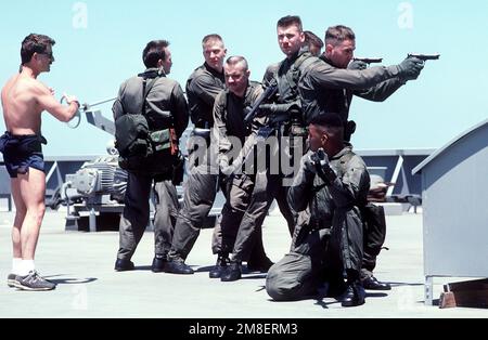 Un membre de l'équipe Sea-Air-Land (SEAL) 8, s'entretient avec les membres du détachement de la Marine du porte-avions à propulsion nucléaire USS THEODORE ROOSEVELT (CVN-71) pendant l'entraînement de l'équipe d'embarquement à bord du lubrificateur USNS JOSHUA HUMPRHEYS (T-AO-188). L'équipe DU PHOQUE 8 a fourni des équipes d'embarquement pour aider à l'application des sanctions commerciales de l'ONU contre l'Iraq pendant l'opération tempête du désert. Les Marines sont armées de fusils de calibre M-870 12 et de pistolets M-9 9mm. Sujet opération/série: TEMPÊTE DANS LE DÉSERT pays: Mer Rouge Banque D'Images