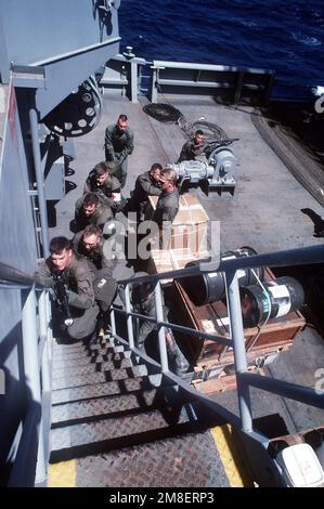 Un membre de l'équipe Sea-Air-Land (SEAL) 8, au centre, regarde comme des membres du détachement de la Marine du porte-avions à propulsion nucléaire USS THEODORE ROOSEVELT (CVN-71) monter une échelle pendant l'entraînement de l'équipe d'embarquement à bord de la flotte oUSNS JOSHUA HUMPRHEiler (T-AO-188). L'équipe DU PHOQUE 8 a fourni des équipes d'embarquement pour aider à l'application des sanctions commerciales de l'ONU contre l'Iraq pendant l'opération tempête du désert. Sujet opération/série: TEMPÊTE DANS LE DÉSERT pays: Mer Rouge Banque D'Images