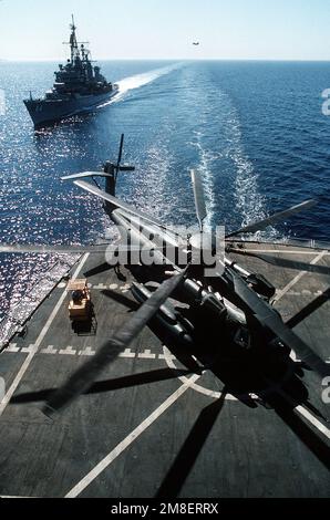 Les membres de l'équipage à bord de la flotte militaire de ravitaillement commandée par le Commandement USNS JOSHUA HUMPHREYS (T-AO-188) déchargent un hélicoptère CH-53E Super Stallion à la suite de l'opération Desert Storm alors que le destroyer de missile guidé USS WILLIAM V. PRATT (DDG-44) s'approche de derrière. Le PRATT mène des missions de la Force d'interdiction maritime à l'appui des sanctions commerciales américaines contre l'Irak. Sujet opération/série: TEMPÊTE DANS LE DÉSERT pays: Mer Rouge Banque D'Images