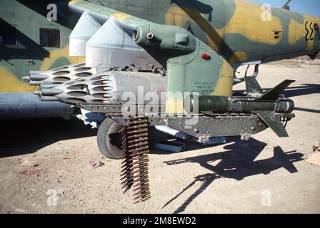 Vue rapprochée de l'aile gauche d'un hélicoptère d'assaut mi-24 Hind-D de la MIL iraquienne abandonné pendant l'opération tempête du désert. L'ordnance est constituée de deux fusées UV-32-57 contenant chacune 32 fusées S-5 57mm et d'un missile ANTI-char AT-2 Swatter. Une ceinture de 12,7mm munitions de mitrailleuse est drapée au-dessus du rail de lancement de missile. Objet opération/série : TEMPÊTE DANS LE DÉSERT pays : Irak (IRQ) Banque D'Images