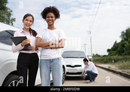 Les femmes chauffeurs s'en rendent à l'agent d'assurance pour examiner la voiture endommagée et les vérifications des clients sur le formulaire de déclaration de sinistre après un accident. Concept d'assurance, Banque D'Images