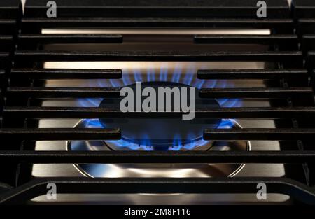 Cuisine moderne cuisinière. Flamme de gaz gros plan sur un brûleur de cuisinière à gaz naturel avec grill en métal Banque D'Images