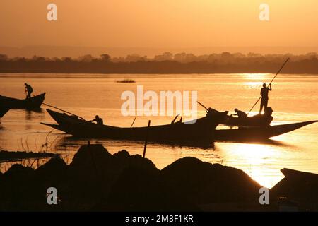 Des barges polaires sur le Niger dans la lueur du dernier soleil sur une jetée près de Bamako, Mali Banque D'Images