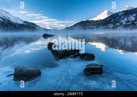 Lake St. Moritz avec brouillard et glace le matin au premier plan au lever du soleil, St. Moritz, canton des Grisons, Suisse Banque D'Images