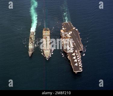 Une vue de l'avant-plan de l'huileur de réapprovisionnement USS KANSAS CITY (AOR-3) qui mène à un réapprovisionnement en cours du porte-avions USS RANGER (CV-61) et du CROISEUR de missiles guidé USS VALLEY FORGE (CG-50). Pays : Océan Pacifique (POC) Banque D'Images