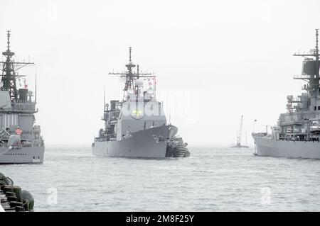 Un gros remorqueur de port vient le long du croiseur à missiles guidé USS THOMAS S. GATES (CG-51) alors que le navire approche de son quai à l'embarcadère. Le THOMAS S. GATES revient à Norfolk après son déploiement dans la région du golfe Persique pour l'opération Desert Shield et l'opération Desert Storm. Objet opération/série: BOUCLIER DU DÉSERT TEMPÊTE DU DÉSERT base: Naval Air Station, Norfolk État: Virginie (va) pays: États-Unis d'Amérique (USA) Banque D'Images