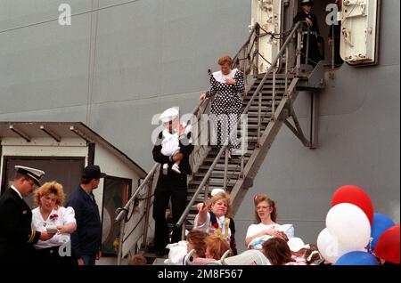 Un marin est réuni avec sa famille après son arrivée au port à bord d'un des navires du groupe de combat USS JOHN F. KENNEDY (CV-67). Les navires sont retournés à Norfolk après leur déploiement dans la région du golfe Persique au cours de l'opération tempête du désert. Objet opération/série: TEMPÊTE DU DÉSERT base: Naval Air Station, Norfolk État: Virginie (va) pays: États-Unis d'Amérique (USA) Banque D'Images