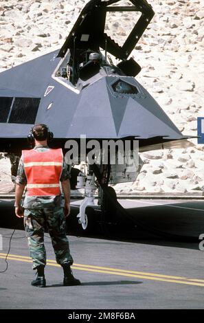 PERSONNEL SGT. David Owings, chef d'équipe, communique avec LE MAJ. Joe Bowley, un pilote de chasse de l'aile tactique de 37th, alors que Bowley effectue un contrôle en amont de son avion F-117 Stealth Fighter en préparation au redéploiement aux États-Unis après l'opération Desert Storm. Objet opération/série : TEMPÊTE DANS LE DÉSERT pays : Arabie saoudite (SAU) Banque D'Images