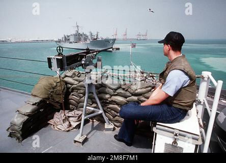 Un membre de l'équipage à bord du navire de commandement amphibie USS BLUE RIDGE (LCC-19) regarde le navire de réparation USS NIAGARA FALLS (AFS-3) alors qu'il est équipé d'une mitrailleuse de calibre M-2 .50. Les deux navires ont été déployés dans la région du golfe Persique pendant les opérations Bouclier du désert/tempête du désert. Objet opération/série : BOUCLIER DU DÉSERT TEMPÊTE DU DÉSERT pays : Bahreïn (BHR) Banque D'Images