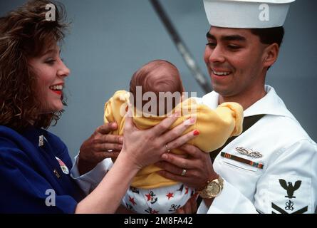 Un membre de l'équipage du cargo amphibie USS DURHAM (LKA-114) est réuni avec sa famille après l'arrivée du navire au port. Le DURHAM est revenu à San Diego après son déploiement dans la région du golfe Persique au cours de l'opération tempête du désert. Objet opération/série: DESERT STORM base: Naval Air Station, San Diego État: Californie (CA) pays: États-Unis d'Amérique (USA) Banque D'Images