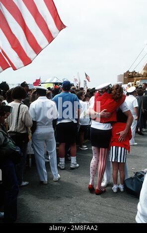 Un officier du porte-avions USS AMERICA (CV-66) est réuni avec sa famille après l'arrivée du navire au port. L'AMÉRIQUE vient de rentrer à Norfolk à la suite d'un déploiement dans la région du golfe Persique au cours de l'opération tempête du désert. Objet opération/série: TEMPÊTE DU DÉSERT base: Naval Air Station, Norfolk État: Virginie (va) pays: États-Unis d'Amérique (USA) Banque D'Images