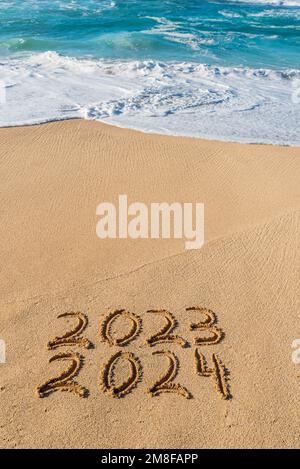 2023 2024 écrit dans le sable avec la vague de lavage - concept de nouvel an Banque D'Images