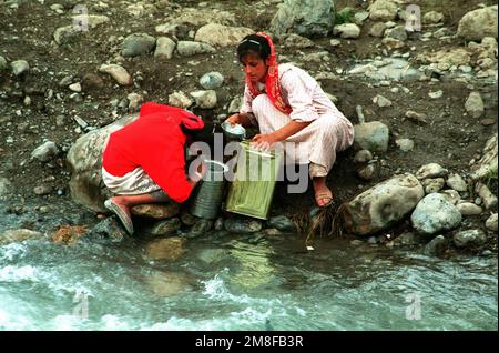 Deux femmes kurdes remplissent leurs bidons d'eau depuis un ruisseau dans un camp de réfugiés près de la frontière turque avec l'Irak. Les camps ont été établis par les milliers de Kurdes qui ont fui leurs foyers dans le nord de l'Irak pour échapper aux forces gouvernementales irakiennes. Des troupes des États-Unis et d'autres nations sont venues dans les camps pour distribuer l'aide et préparer les réfugiés à se déplacer dans les camps organisés en Irak dans le cadre de l'opération fournir le confort. Sujet opération/série : FOURNIR LE CONFORT pays : Turquie (TUR) Banque D'Images