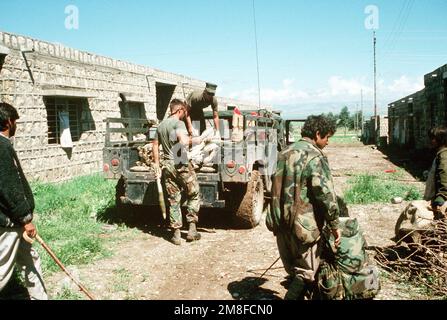 Les résidents locaux se réunissent pour observer les Marines d'une équipe chargée de l'élimination des munitions explosives (EOD) rattachée au groupe d'assistance technique 24 de l'unité expéditionnaire maritime (MEU) (MSSG-24) lorsqu'elles chargent des munitions à l'arrière d'un véhicule à roues polyvalent à haute mobilité (HMMWV) M998. L'élimination des munitions iraquiennes rejetées est menée conjointement avec l'opération fournir confort, un effort multinational pour aider les réfugiés dans le nord de l'Iraq et le sud de la Turquie. Sujet opération/série: FOURNIR LE CONFORT base: Zakhu pays: Irak (IRQ) Banque D'Images