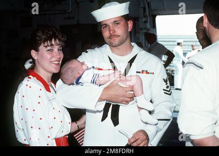 Un marin du navire USS SAN DIEGO (AFS-6) des magasins de combat est réuni avec sa famille après l'arrivée du navire au port. Le SAN DIEGO est retourné à Norfolk après avoir été déployé dans la région du golfe Persique pendant l'opération tempête du désert. Objet opération/série: TEMPÊTE DU DÉSERT base: Naval Air Station, Norfolk État: Virginie (va) pays: États-Unis d'Amérique (USA) Banque D'Images