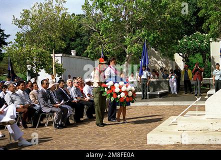 Un scout de garçon et une scoute de fille portent une couronne à la base d'un monument pendant l'observance du jour du souvenir au cimetière national du Pacifique, également connu sous le nom de Punchbowl. Base: Honolulu État: Hawaii(HI) pays: Etats-Unis d'Amérique (USA) Banque D'Images