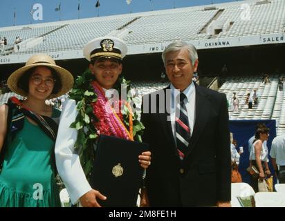 Un nouvel enseigne de la classe de 1991 de l'Académie navale détient son diplôme en présence de deux de ses invités après la fin de la cérémonie de remise des diplômes et de mise en service de l'académie. Près de 20 000 invités ont assisté à la cérémonie au stade Marine-Marine corps, au cours de laquelle 937 midshipmen ont été diplômés. Base: US Naval Academy, Annapolis State: Maryland(MD) pays: Etats-Unis d'Amérique (USA) Banque D'Images
