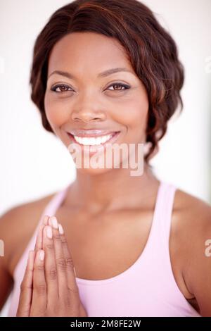 Trouver sa paix intérieure. Une belle jeune femme afro-américaine se détendant avec une routine de yoga. Banque D'Images