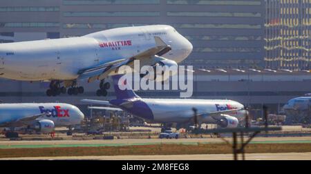 Détails de l'aéroport LAX à Los Angeles, Californie, États-Unis. Photo : un Boeing 747 de Kalitta Air quitte LAX, avec un avion cargo FedEx sur le tarmac ci-dessous. Banque D'Images