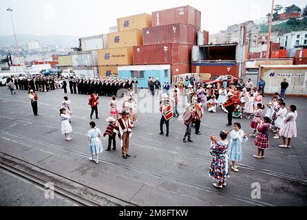 Des marins chiliens et un groupe de la marine se tiennent près d'un danseur local qui s'amusent aux États-Unis Personnel de la Marine à leur arrivée au port. Plusieurs navires américains sont à Valparaiso dans le cadre de l'Unitas XXXII, un exercice combiné impliquant les forces navales des États-Unis et neuf nations sud-américaines. Sujet opération/série: UNITAS XXXII base: Valparaiso pays: Chili(CHL) Banque D'Images