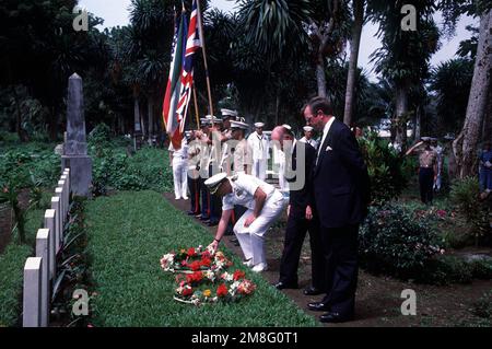 Des officiers du navire-citerne USS BARNSTABLE COUNTY (LST-1197) et des dignitaires nationaux latent des couronnes sur les tombes des aviateurs britanniques morts pendant la Seconde Guerre mondiale lors d'un service commémoratif à Malabo, en Guinée équatoriale, sur l'île de Bioko, En tant que garde de couleur marine et l'équipage du navire sont à l'attention. Le COMTÉ DE BARNSTABLE se rend dans les pays d'Afrique de l'Ouest lors de sa croisière d'entraînement en Afrique de l'Ouest en 1991. Pays: Afrique de l'Ouest Banque D'Images