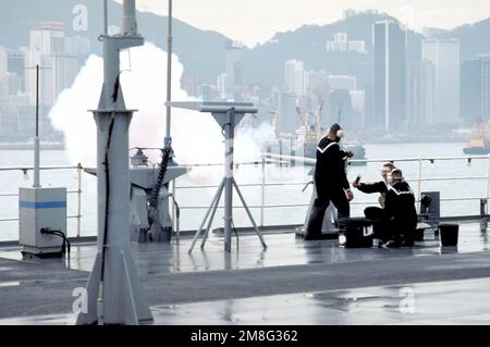 Un membre de l'équipage à bord du navire de commandement amphibie USS BLUE RIDGE (LCC-19) tire un fusil de salinisation alors que le navire rend hommage à 21 canons à son arrivée à la station navale britannique HMS Tamar. Base: Hong Kong pays: Hong Kong(HKG) Banque D'Images