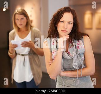 L'art signifie différentes choses à différentes personnes. deux jeunes femmes regardant des peintures dans une galerie. Banque D'Images